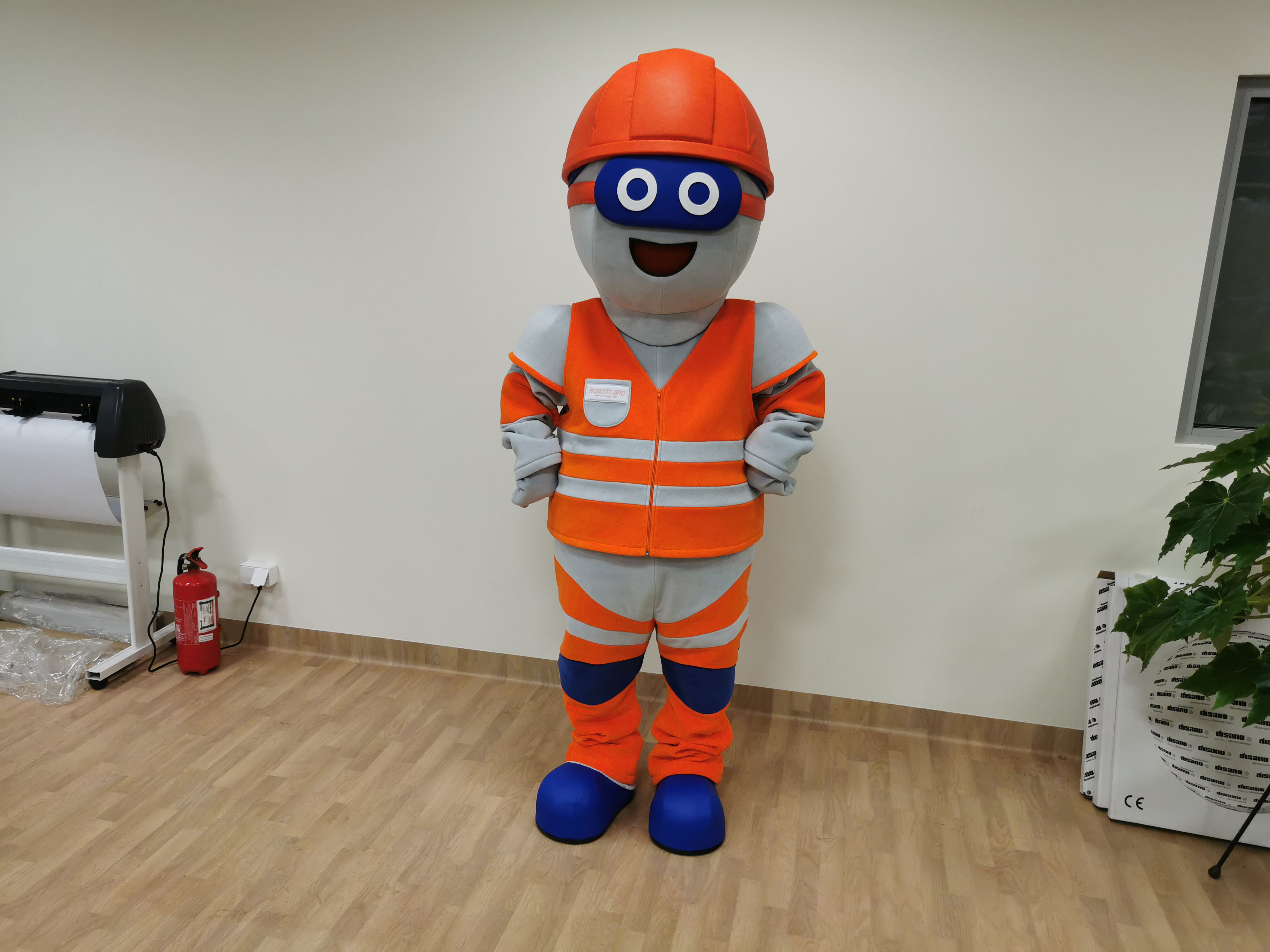 Na fotografii widnieje przebranie reklamowe stylizowane na postać robota pozujące do zdjęcia w siedzibie firmy Elabika